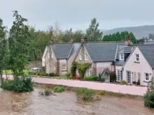 River Dee with high water level and houses in the foreground. A hill can be seen in the background. Photo credit: Rachel Helliwell