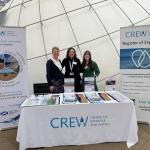 CREW stand with three staff at conference