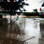 Person stepping in surface water with street in background - Photo credit: Julian Scott