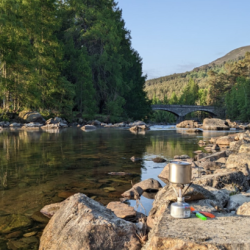 River with camping stove on stones in foreground. Photo credit: Rachel Helliwell